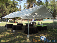 mesas redondas con manteles negros en carpa